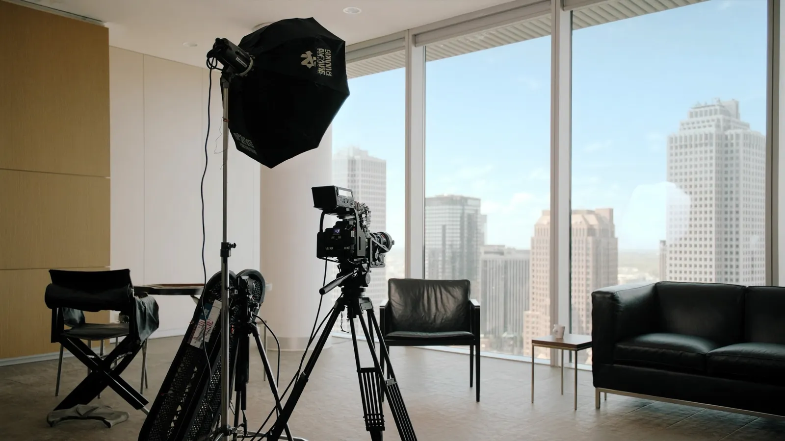 Corporate interview setup with cinema camera and softbox lighting in a bright Dallas office
