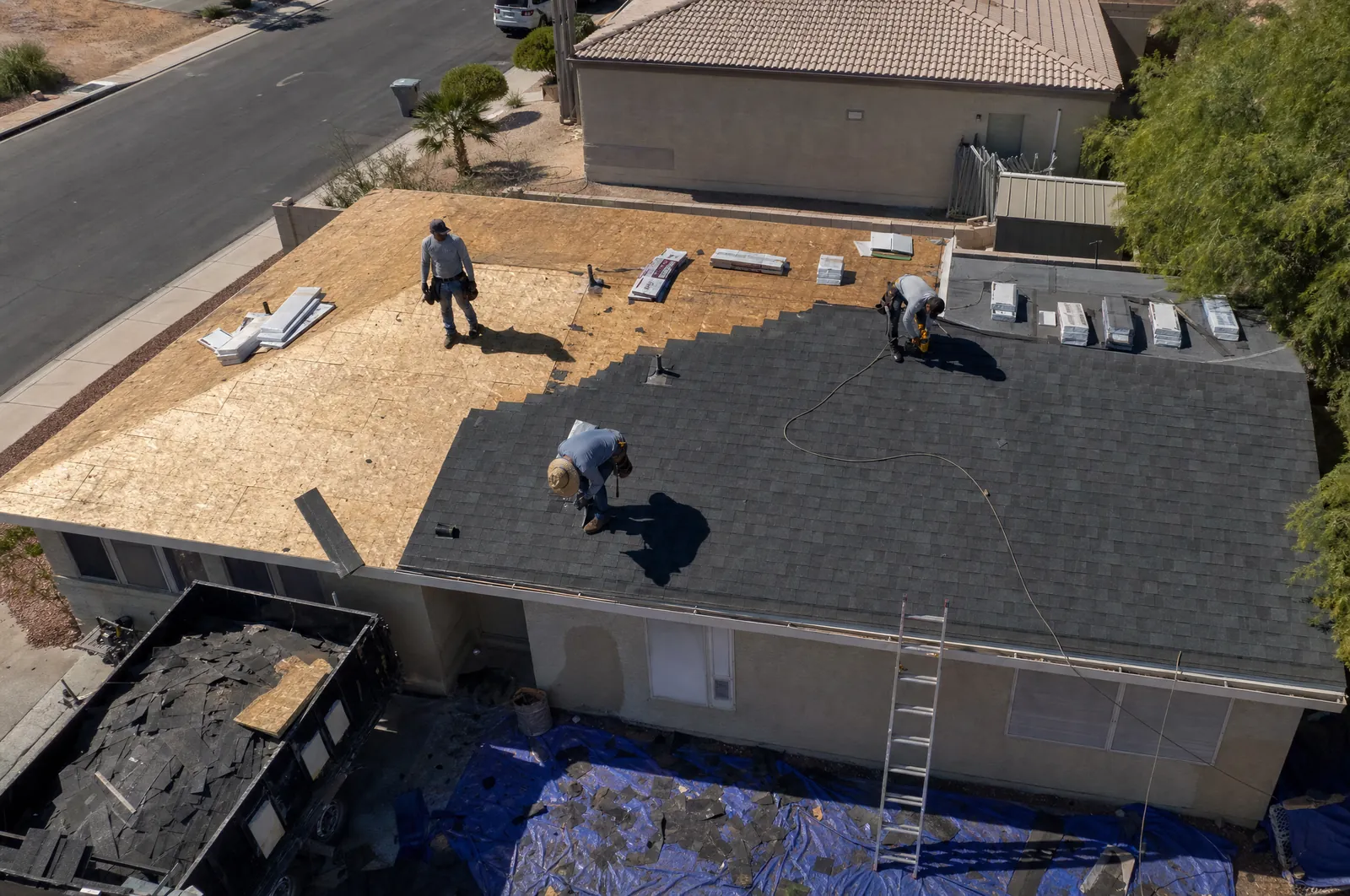 Roofing crew replacing shingles, seen from a drone (AI-generated illustration)
